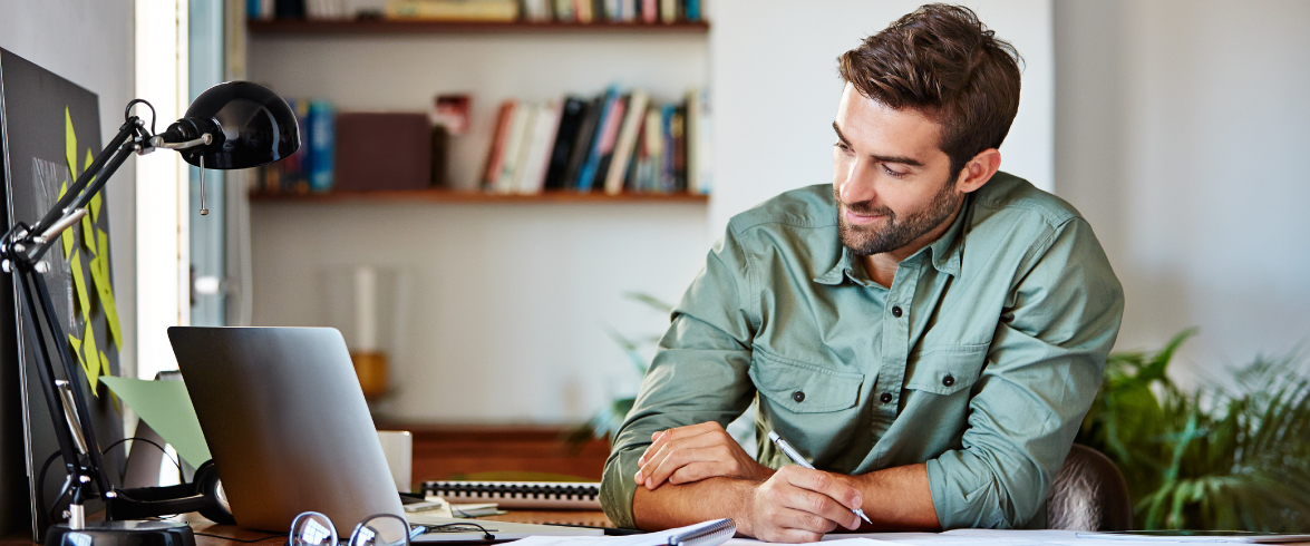 Cropped shot of a young man making notes while working at home.